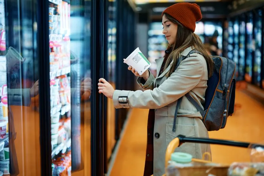 woman buying ice cream looking at nutrition label